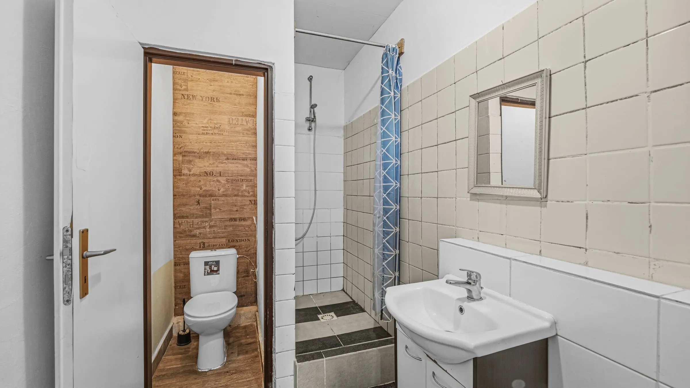 Koupelna se sprchovým koutem a umyvadlem, vedle samostatné WC